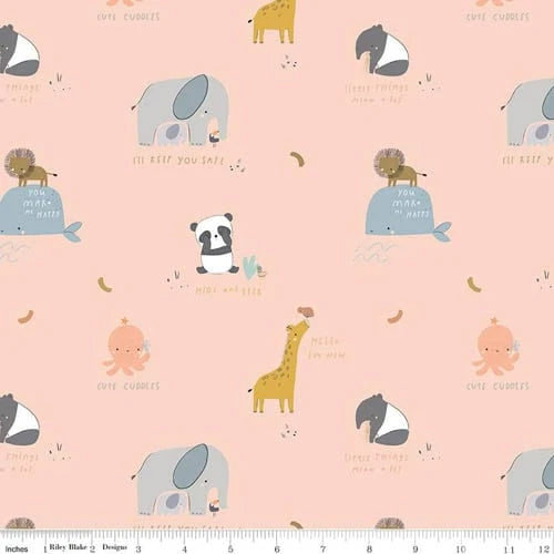 The Little Things 3 Yard Quilt Top Bundle by Quilted Joy features 100% cotton pastel pink fabric with illustrated animals, whimsical phrases, and tiny bananas—perfect for Fabric Cafe quilt patterns. A ruler appears at the bottom edge.