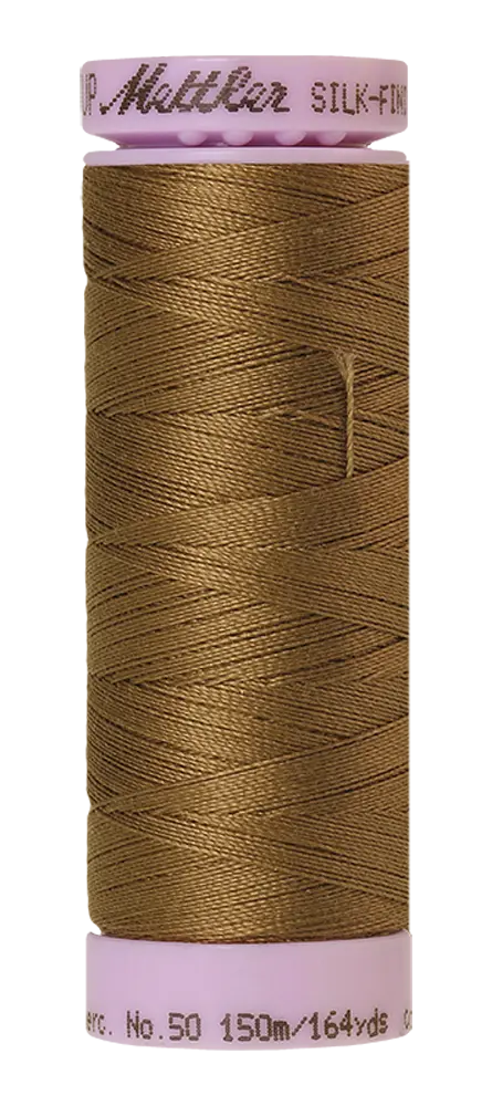 A spool of Mettler Cotton Silk Finish 50wt quilting thread in Dormouse brown, 150m/164yds, with pink ends and labeled “Mettler Silk-Finish.”.