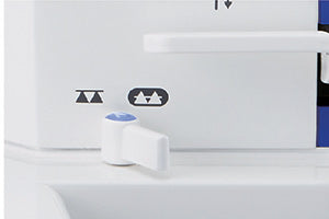 The drop feed lever on the bed of the JUKI Haruka TL-18QVP, with the raised and lowered feed dog icons printed beside it.