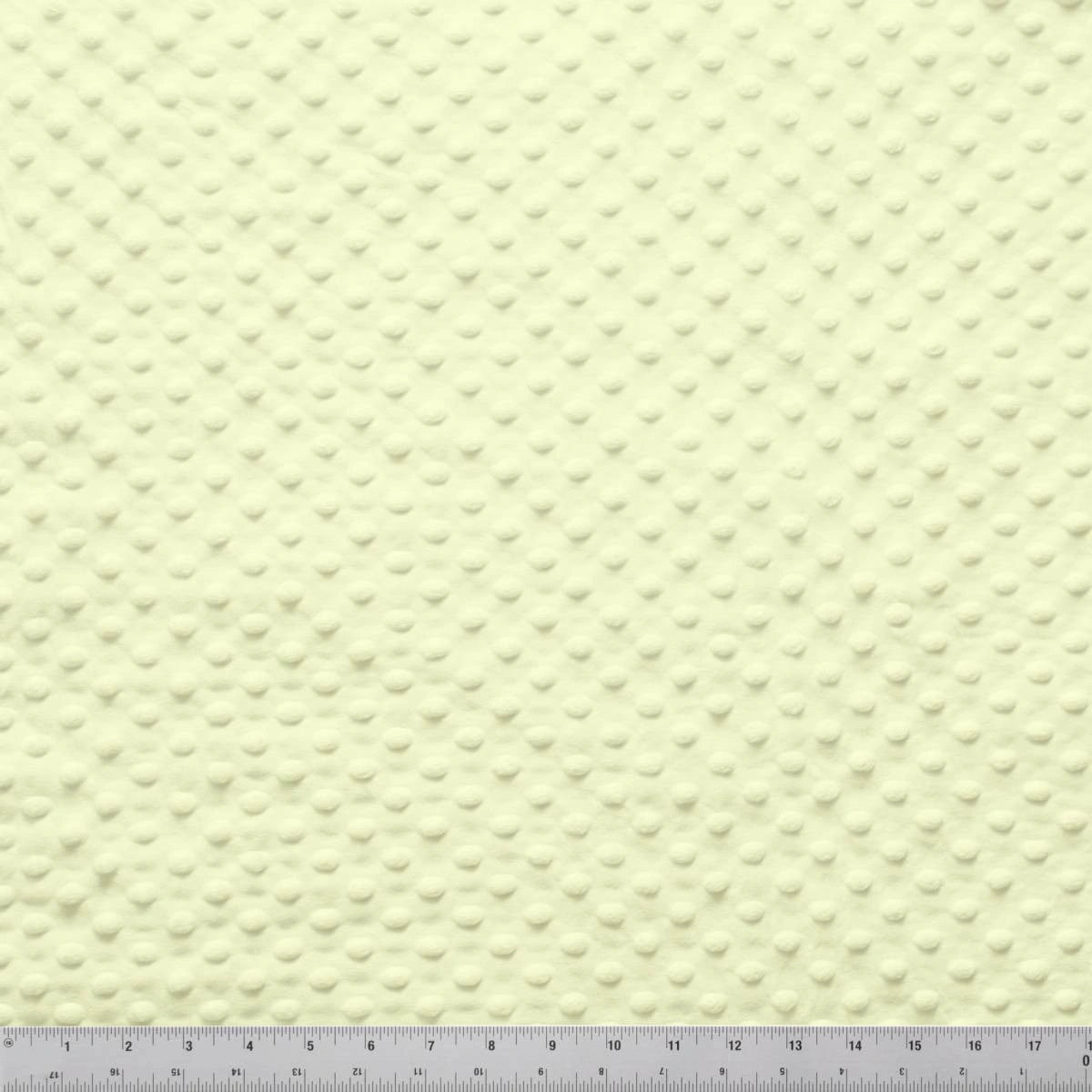 A close-up of Minky Dots Lemon 60" Wide Quilt Backing Fabric by Jaftex - Henry Glass Fabrics displays its soft, plush texture and dimpled surface, with a ruler at the bottom providing measurements for scale.