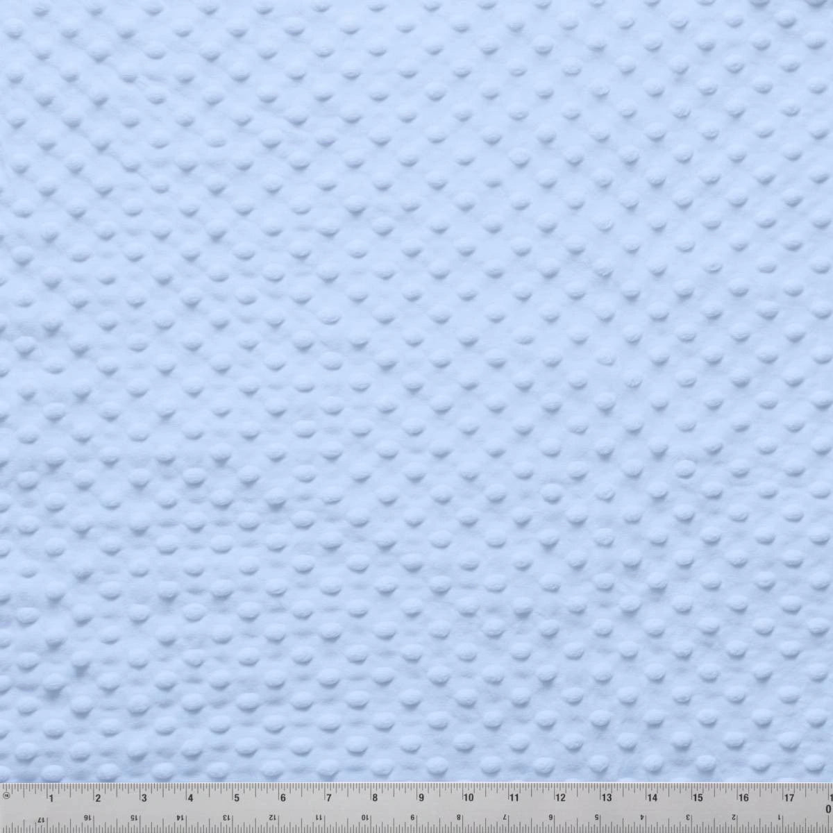 Jaftex - Henry Glass Fabrics Minky Dots Light Blue 60" Wide Quilt Backing Fabric features a soft raised dot texture, ideal for baby quilt backs. For scale, a measuring ruler is shown along the bottom edge.