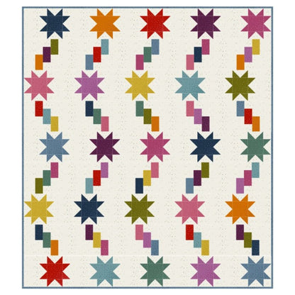 The Fairy Dust Quilt Kit by Quilted Joy features rows of colorful eight-pointed stars with diagonal, stepped stripes on a white background and a slim blue border.