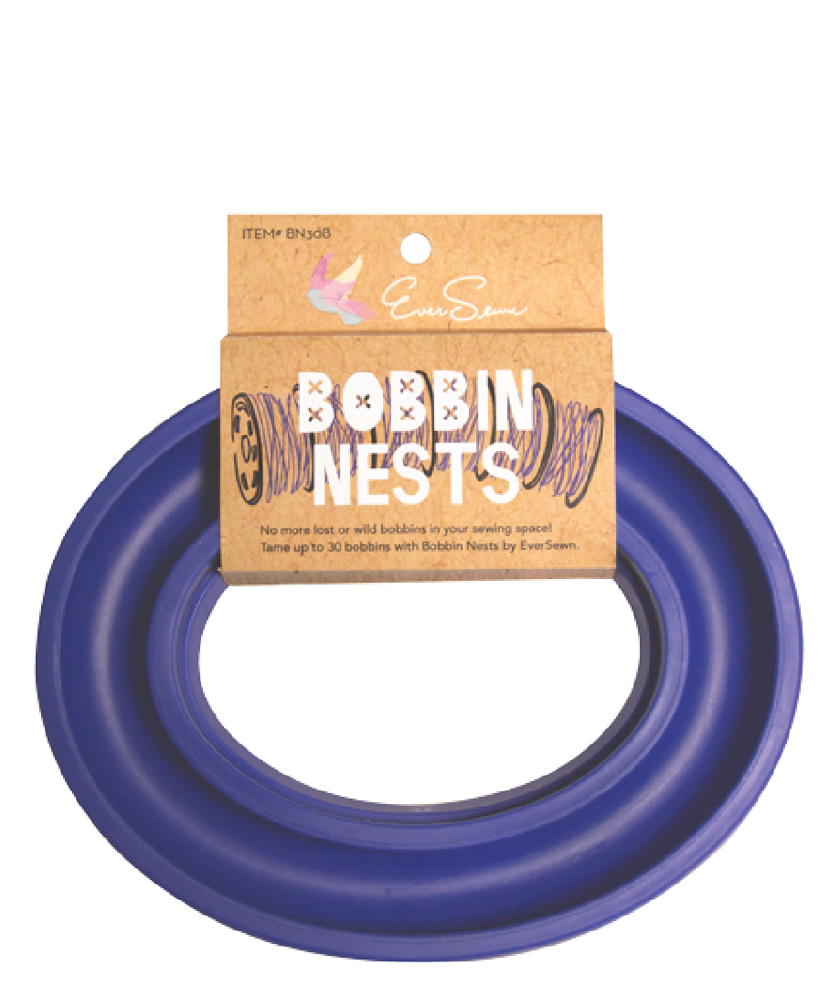 The Eversewn Blue Bobbin Nest by Brewer Sewing is a blue circular bobbin holder, shown in its packaging with a brown cardboard label—an ideal organizer for keeping your threads tidy.