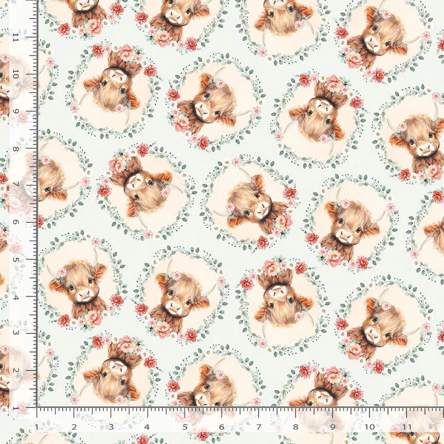 Timeless Treasures 'Til the Cows Come Home Sky Cow Heads & Floral Fabric Yardage features illustrated cows in floral wreaths on a pale background with an inch ruler for scale—ideal for baby quilts or farmhouse projects.