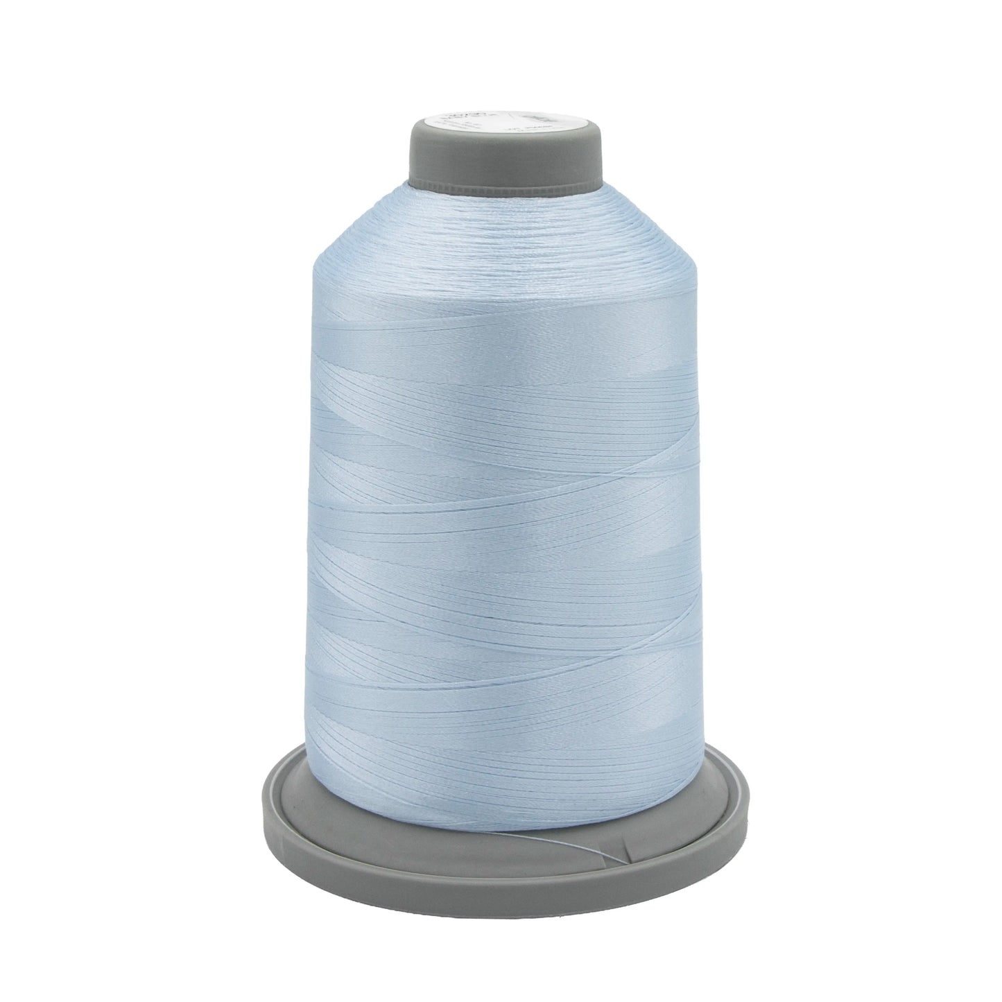 A large spool of Hab+Dash Glide Thread Baby Blue 30290 polyester sits upright on a gray base, the thread wound smoothly around the cone—ideal for machine quilting projects.