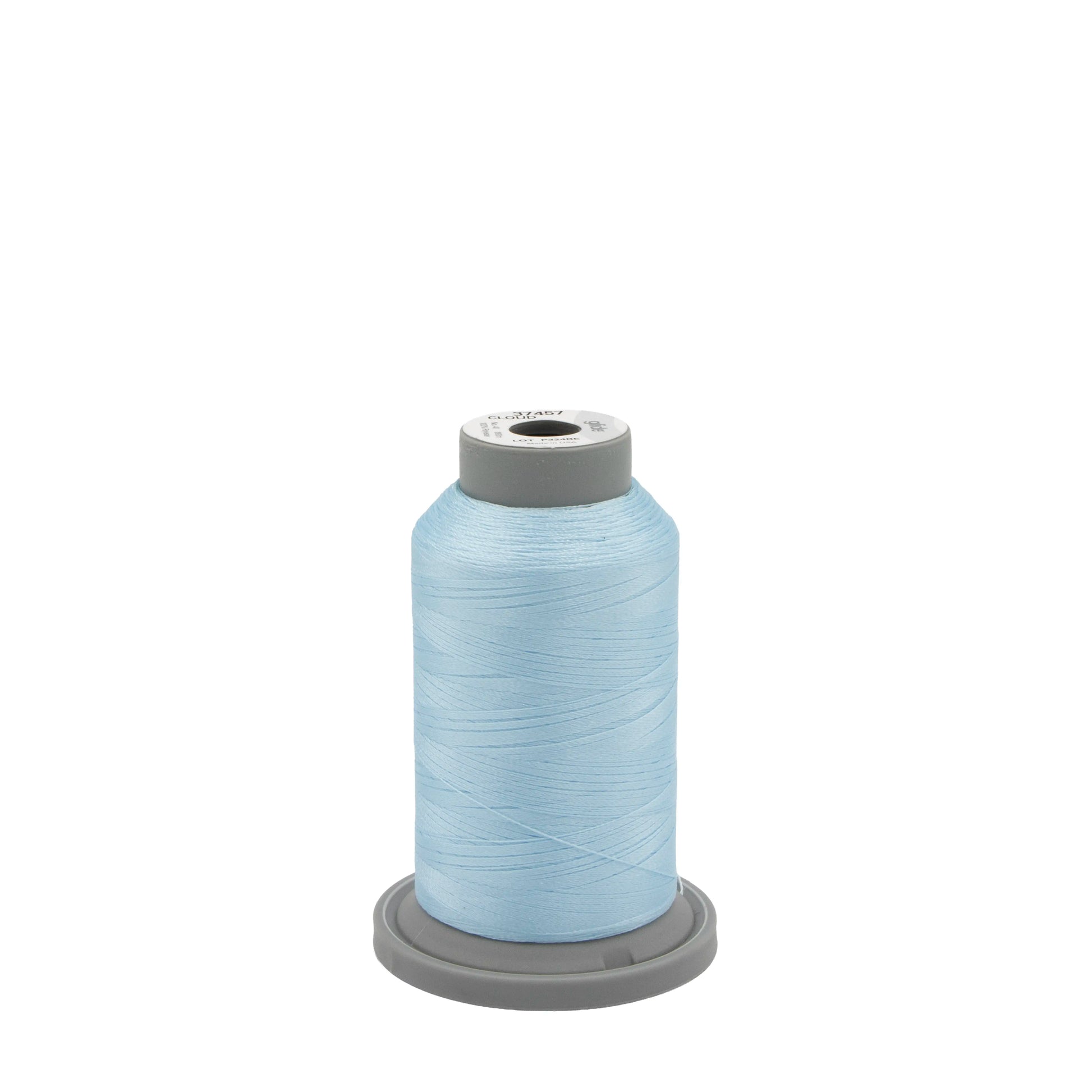 A large spool of Hab+Dash Glide Thread Cloud 37457 polyester thread sits upright on a gray plastic base, ideal for machine quilting, against a plain white background.