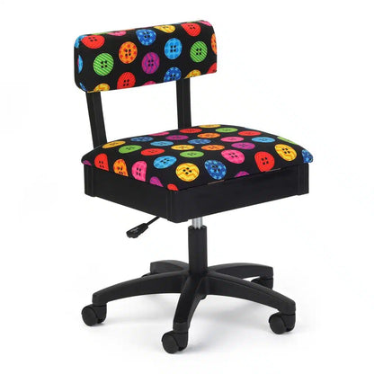 The Arrow Hydraulic Buttons Chair is a black ergonomic sewing chair with wheels, adjustable height, a backrest, and fabric upholstery featuring a colorful pattern of buttons in various sizes.