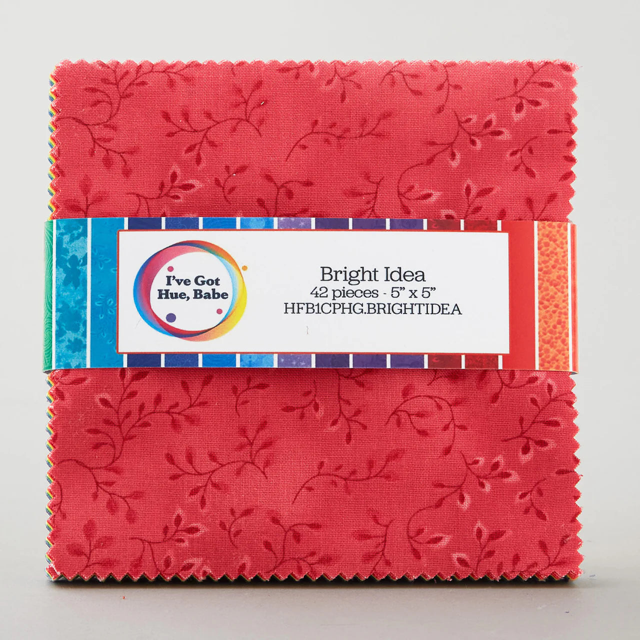 A stack of 42 square red quilt precuts (5" each) with a leaf pattern, from Jaftex - Henry Glass Fabrics' "I've Got Hue, Babe Bright Idea 5" Squares" collection, wrapped in a colorful band.