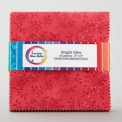 A stack of 42 square red quilt precuts (5" each) with a leaf pattern, from Jaftex - Henry Glass Fabrics' "I've Got Hue, Babe Bright Idea 5" Squares" collection, wrapped in a colorful band.