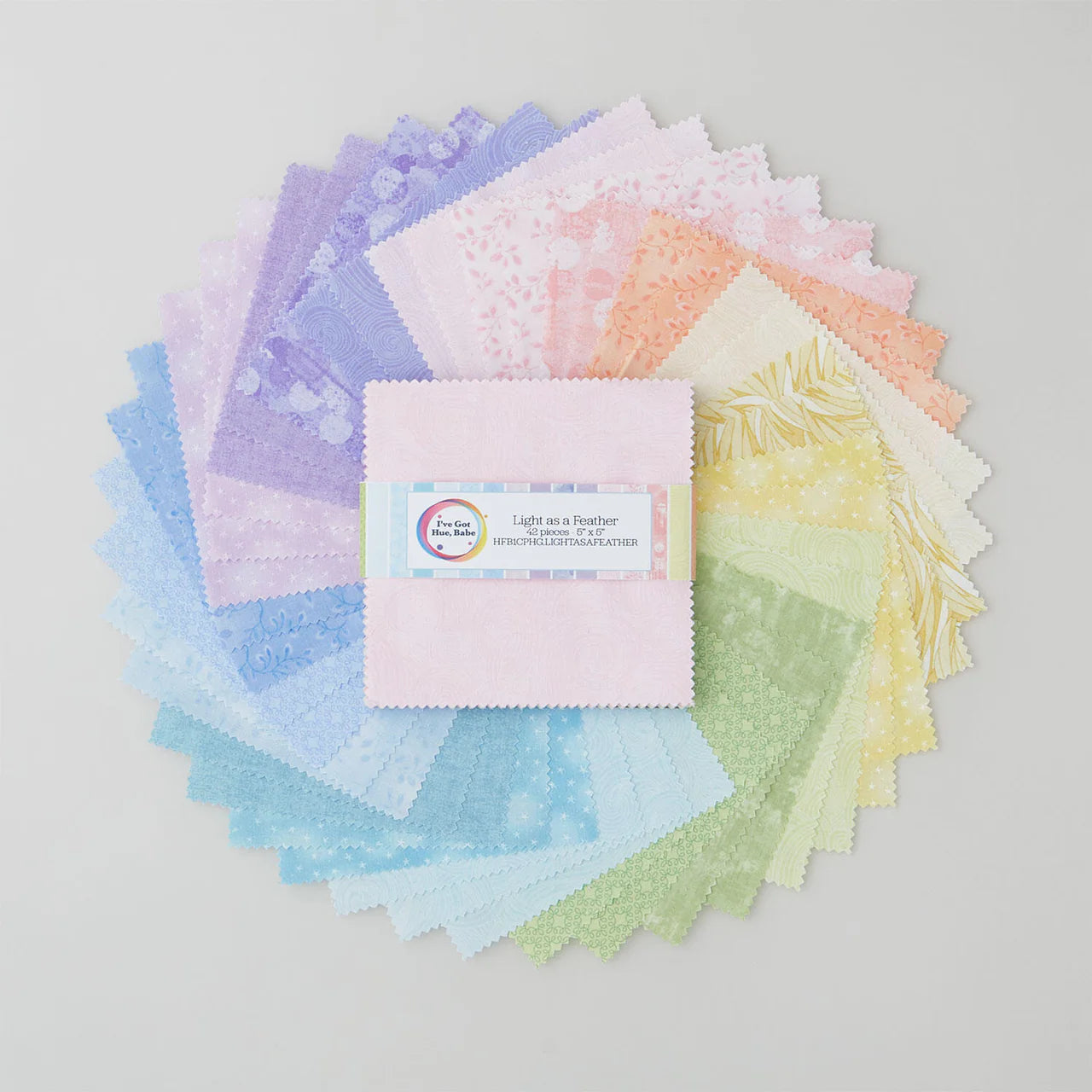 A circle of pastel 5" squares in purple, pink, yellow, green, and blue surrounds the “I’ve Got Hue, Babe Light as a Feather” bundle by Jaftex - Henry Glass Fabrics. Ideal for quilting or precut squares projects!.