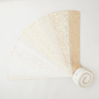 The I've Got Hue, Babe Crème de la crem 2.5in Strips from Jaftex - Henry Glass Fabrics are displayed in a fan shape, featuring neutral beige and white tones with subtle patterns and textures on each strip.