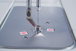 The needle and hopping foot of the JUKI Miyabi J-350QVP over the machine bed, illustrating the JUKI SmartStitch stitch regulator system.
