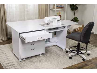 The Koala Quilters Vision Sewing and Companion Chest in White and Gray is shown with open drawers, a sewing machine on top, a gray office chair, shelving with thread spools, plus a rug, plant, and sheer curtains in a bright room.
