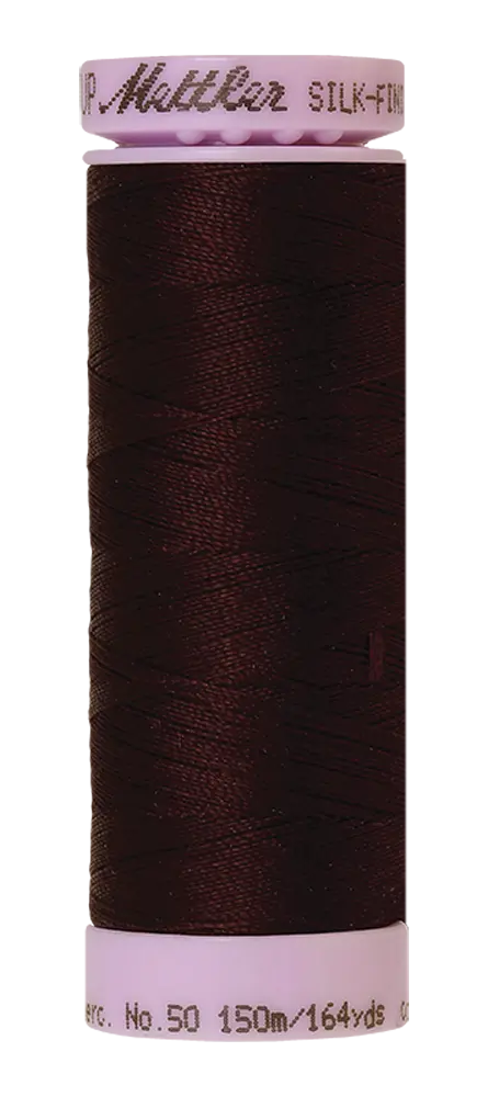 A spool of Mettler Cotton Silk Finish 50wt thread in Mahogany, 150m/164yds, ideal for cotton sewing and quilting projects.