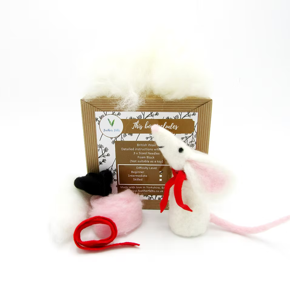 The Feather Felts White Mouse - Needle Felting Kit No Foam includes supplies, loose wool, pink ears, a black hat, red scarf and yarn, pink wool, and instructions to create a felted white mouse—displayed on a white background.