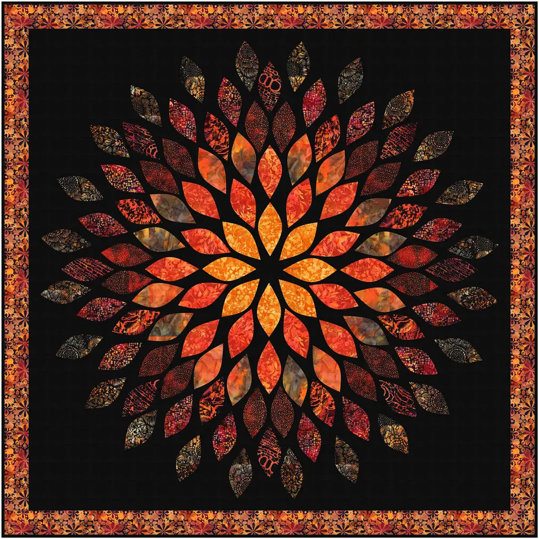 The Mums the Word Quilt Kit by Quilted Joy features a fusible appliqué design on a black background with a large, symmetrical flower pattern in orange, red, and yellow Hoffman Bali Batiks leaves, framed with a matching border.