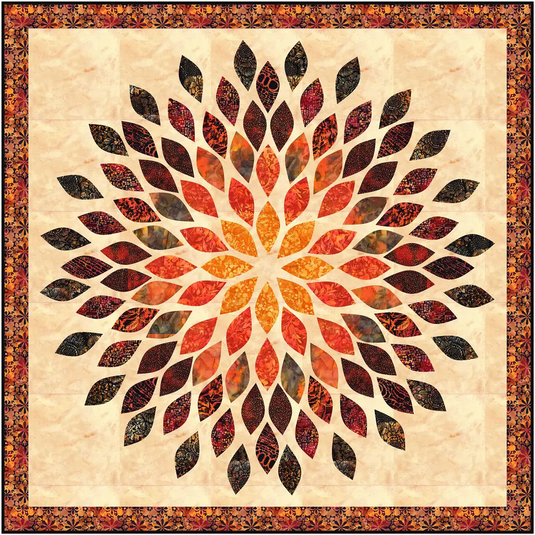 The Quilted Joy Mums the Word Quilt Kit features a fusible appliqué design with a bold, radial floral pattern in orange, brown, and black on beige, bordered by ornate florals—ideal for fans of striking quilt artistry.