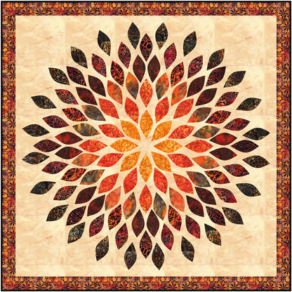 The Quilted Joy Mums the Word Quilt Kit features a fusible appliqué design with a bold, radial floral pattern in orange, brown, and black on beige, bordered by ornate florals—ideal for fans of striking quilt artistry.