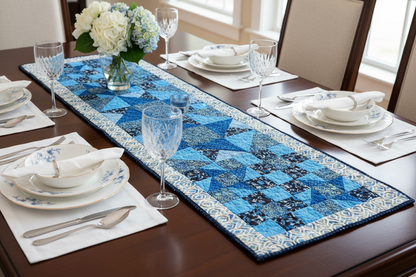 A table set with the Lucky Break pattern from Quilted Joy's Mystery Five-O Ocean Blues Fat Quarter Quilt Kit features elegant wine glasses and rich ocean-inspired tones.