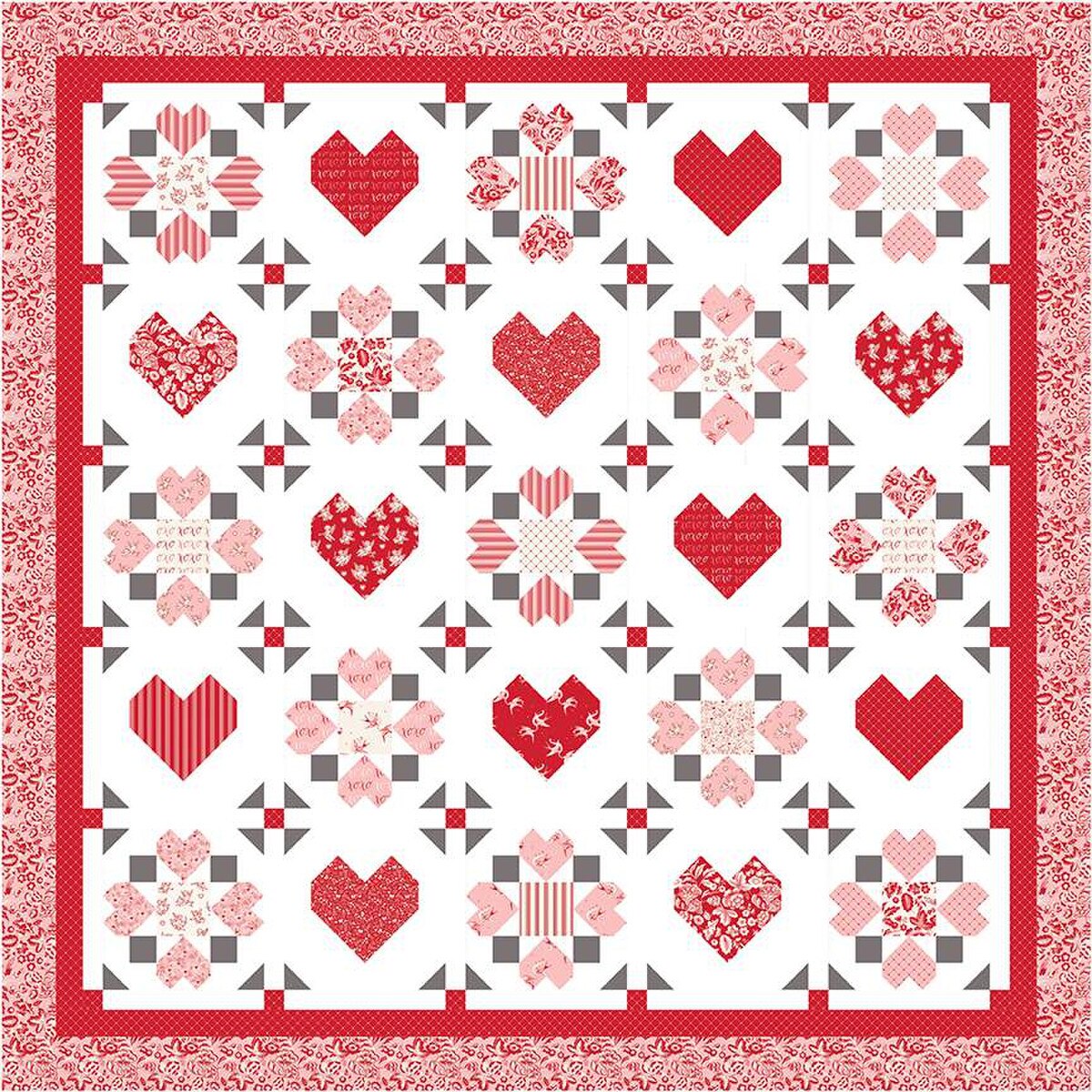 The "Surrounded by Love" quilt pattern by Riley Blake features red and pink hearts and florals in a grid design with a decorative red and white border, and alternating heart and floral blocks on a white background.