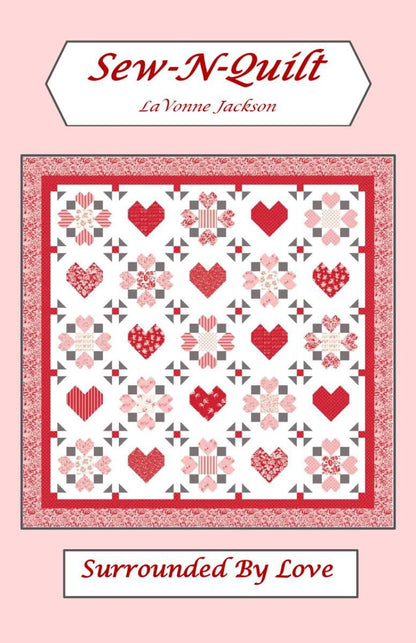 A quilt pattern named "Surrounded by Love" from Riley Blake, featuring red and pink heart and geometric motifs on a white background with a matching border; text includes Sew-N-Quilt, LaVonne Jackson, Surrounded by Love, Riley Blake.