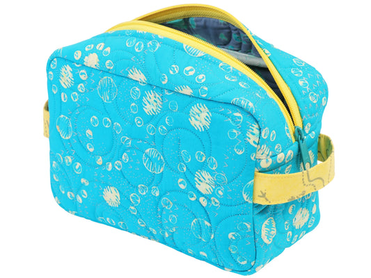 A blue quilted bag with white circles, yellow zipper, and side handle—perfect as a cosmetic pouch or for practicing zipper installation, just like in the Quilted Joy Easy Does It Bag Class.