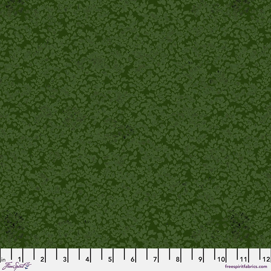 The Chromatics Forest Foliage Fabric Yardage by Jaftex - FreeSpirit features dense leafy green motifs on cotton; a white measuring tape with black numbers from 1 to 12 inches runs along the bottom edge.