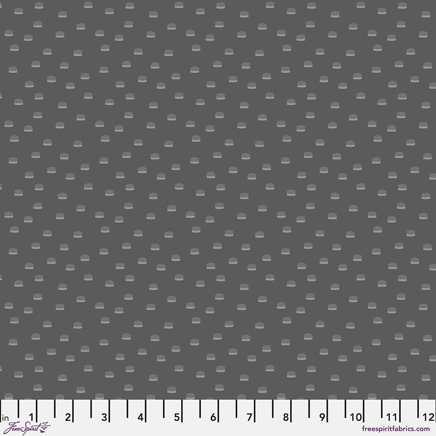 Gray cotton fabric featuring small, evenly spaced light gray oval dots. A measuring tape shows inches 0–12 along the bottom edge. Chromatics Steel Toppers Fabric Yardage by Jaftex - FreeSpirit.