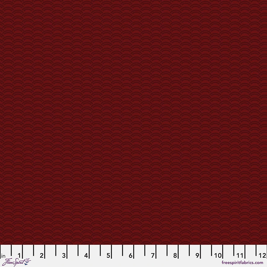 Chromatics Garnet Crescent Fabric Yardage by Jaftex - FreeSpirit features dark red cotton with a subtle repeating wave pattern, perfect for modern patchwork. A white measuring tape (1–12) and freespiritfabrics.com appear along the edges.