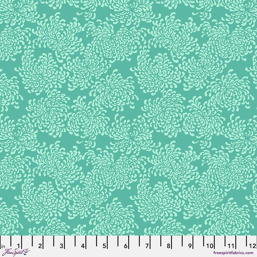 The Utopia Aqua Summer Blossoms Fabric Yardage by Jaftex - FreeSpirit features a teal cotton fabric with light green chrysanthemum-like blossoms in a repeating pattern and a ruler at the bottom edge showing inches from 0 to 12.