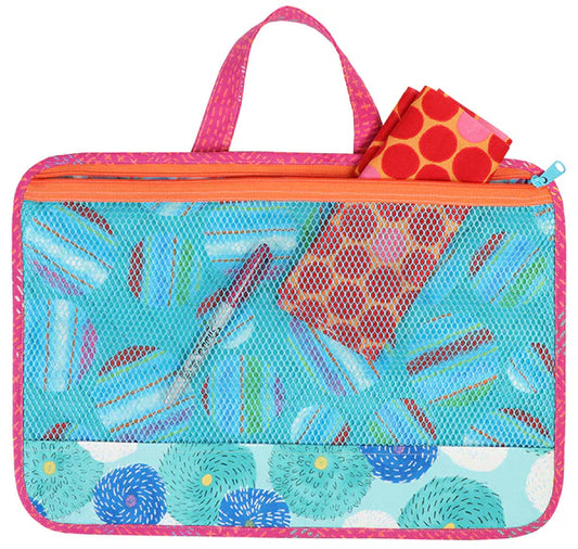The Quilted Joy By Annie Basics - Piecekeeper is a colorful, rectangular pouch with a pink handle, orange zipper, mesh front, and blue donut pattern. It neatly holds a red cloth with orange circles—ideal for organizing fans.