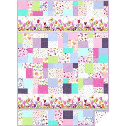 The Quilted Joy Pretty In Pink Quilt Kit features a pastel patchwork of florals, polka dots, and checks, finished with top and bottom borders of tulips, butterflies, and dragonflies.