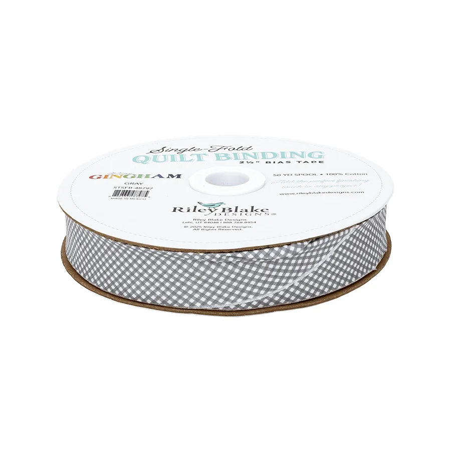 A spool of Riley Blake Micro Gingham Gray 2.5" Bias Quilt Binding, made from 100% cotton, with branded labeling.