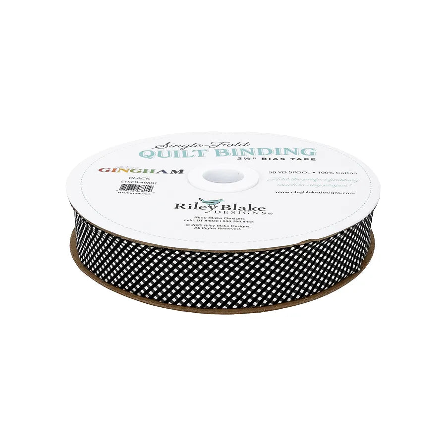 A spool of Riley Blake Micro Gingham Black Single-Fold Quilt Binding features a black and white diagonal checkered pattern and is topped with a white label.