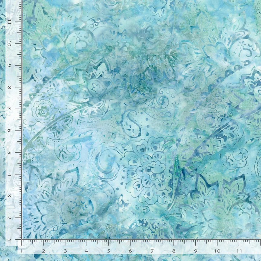 The Tonga Lagoon Fashion Floral Batik Fabric Yardage features blue and green hand-dyed cotton with intricate, swirling flower and leaf patterns, shown here in a 10"x10" sample with rulers along the edges for scale.