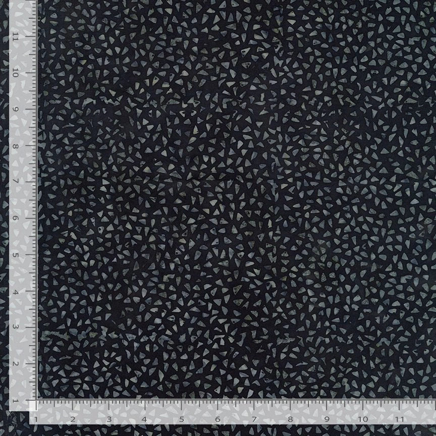 Tonga Charcoal Small Triangle Dots Batik Fabric Yardage showcases small, irregular gray triangles on black. Transparent inch rulers on the left and bottom edges show scale. Perfect for quilt cotton projects.