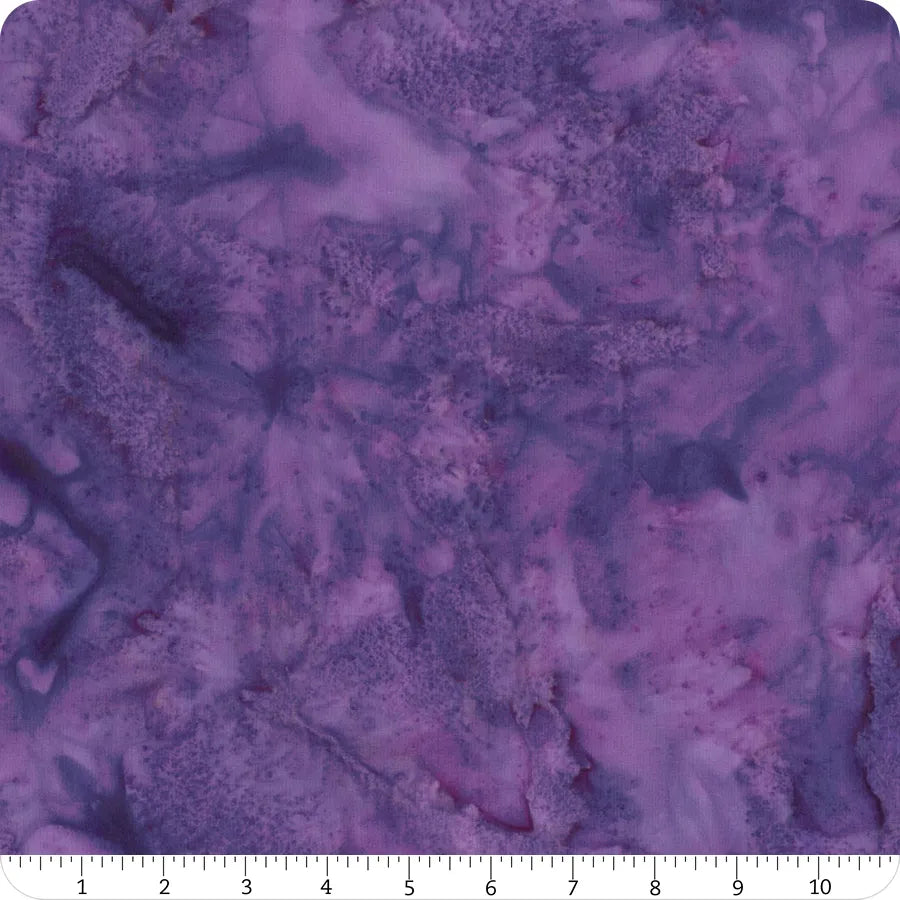 1895 Watercolors Agate Batik 108" wide quilt backing fabric by Hoffman features marbled purple shades of violet, lavender, and plum with a mottled watercolor texture. Includes ruler for inches measurement along the bottom edge.