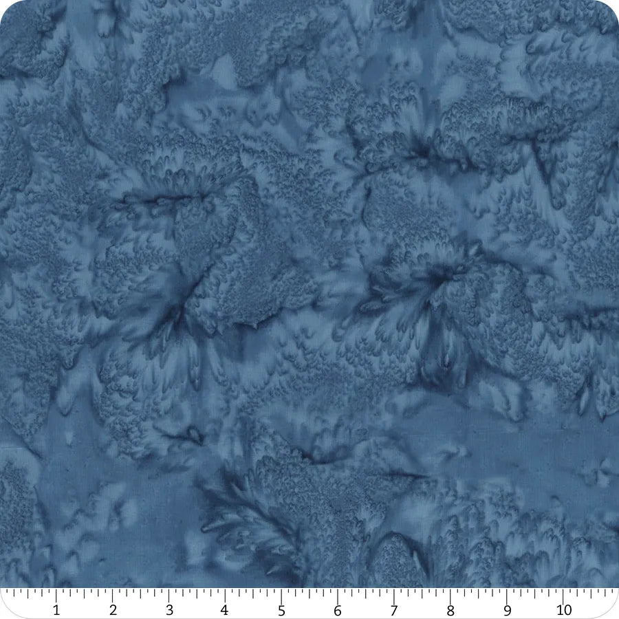 The Hoffman 1895 Watercolors Flax Batik is a 108" wide quilt backing fabric featuring blue marbled patterns with a soft, textured look. Includes a white measuring ruler along the bottom edge in inches for scale.