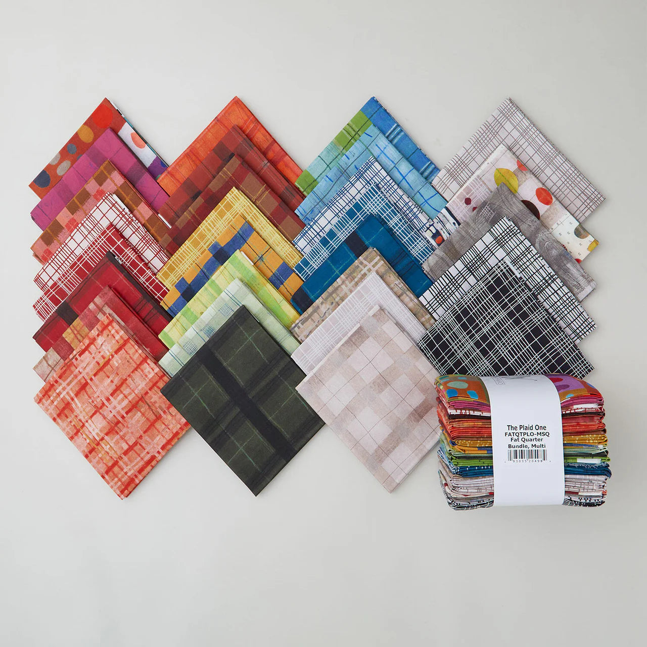 A selection of colorful, patterned fabric squares—including The Plaid One Fat Quarter Bundle 29pc. by Windham Fabrics—arranged on a white surface, with the bundle tied together and displayed on the right.