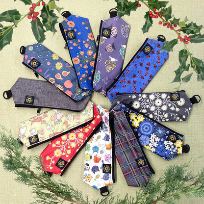 Collection of patterned pouches on a textured surface with greenery