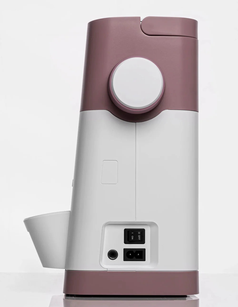 Side view of a pink and white kitchen appliance, with a round dial similar to the precise controls of the Quilted Joy Pfaff Quilt Ambition 635 Sewing and Quilting Machine, plus power ports at bottom right.