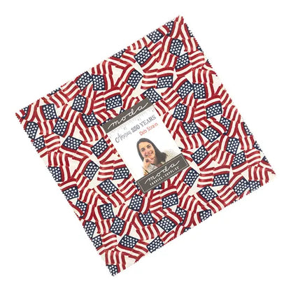 The America 250 Years 10" Layer Cake by United Notions features quilting fabric with small American flags, celebrating America's 250th anniversary. The center label reads “Moda,” “Independence Trail,” and has a photo of a woman.