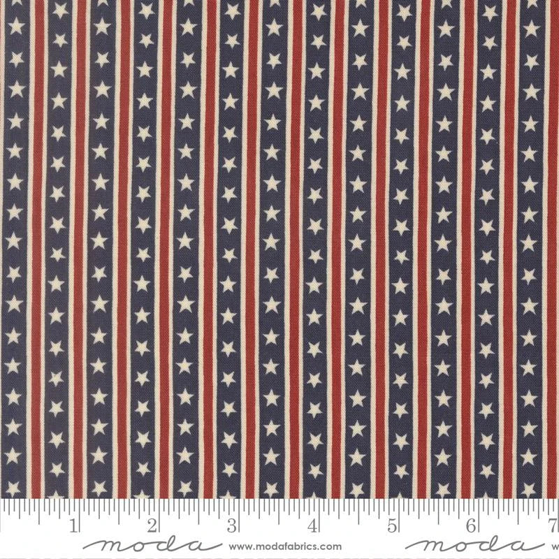 America 250 Years Loyalty Blue Stars in Stripes Fabric Yardage by United Notions features navy blue fabric with vertical white stars and red lines, ideal for patriotic quilting projects. A ruler in inches shows scale.
