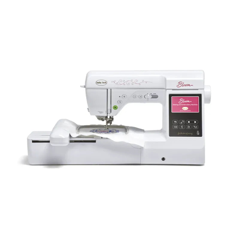 A Baby Lock Bloom Sewing & Embroidery Machine by Baby Lock, featuring a digital screen and controls, sits on a white surface ready for sewing and creative embroidery designs.