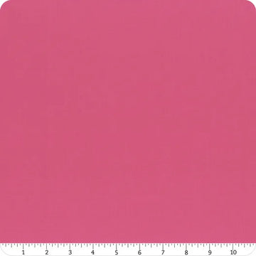 A square piece of Confetti Cotton™ Passion Solid Fabric Yardage by Riley Blake is displayed with rounded corners. A white ruler marked 1–10 inches along the bottom edge shows the scale of this quilting cotton.