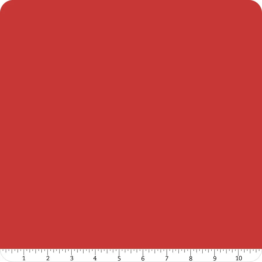 A square of Riley Blake Confetti Cotton™ Barn Red Solid Fabric Yardage with rounded corners is pictured on a white background, with a ruler showing 0–12 inches below—ideal for quilting cotton projects.