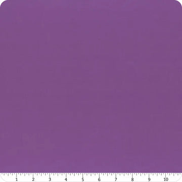 A square piece of Riley Blake Confetti Cotton™ Iris Solid Fabric Yardage with slightly rounded corners is shown, with a ruler along the bottom edge displaying measurements from 0 to 12 inches.