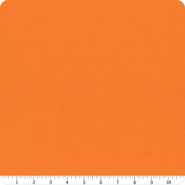 A square swatch of Riley Blake's Confetti Cotton™ Tangerine Solid Fabric Yardage is shown with a white ruler (0–10 inches) along the bottom edge. The fabric has a subtle texture and rounded corners.