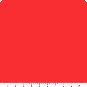 A Confetti Cotton™ Tomato Solid Fabric Yardage by Riley Blake is shown as a red square with rounded top corners and a ruler along the bottom edge, marked from 0 to 11 inches.