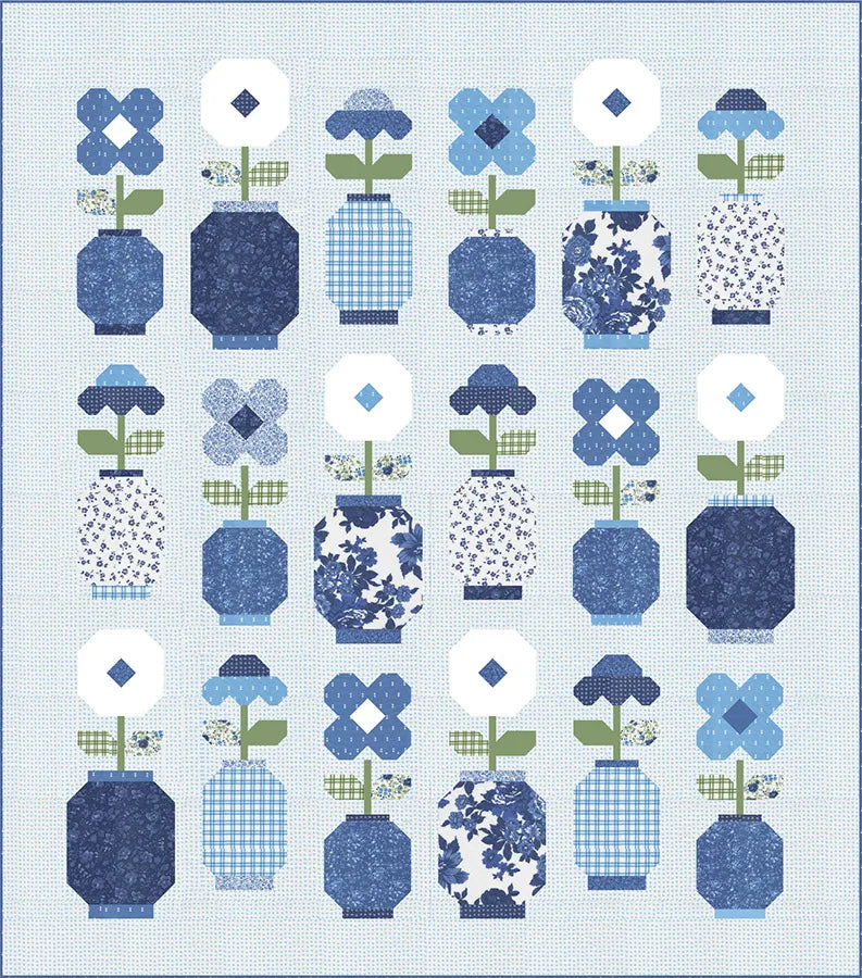 The Blueprint Quilt Kit by United Notions features a grid of blue and white vases inspired by Ginger Jars, each filled with geometric blue flowers on a pale blue background.